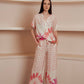Light button-up blouse with a soft pink geometric pattern and tropical floral print at the hem.