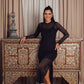 A sleek black midi dress with sheer striped long sleeves